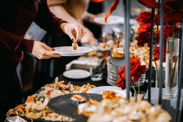 Guest taking a canapé from a buffet table at a catered event