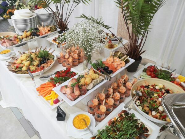 Wedding buffet table with platters of food, salads and flowers